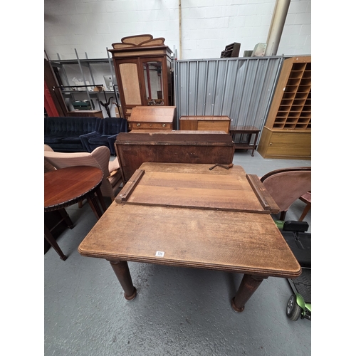 536 - A wind out extending oak dining table with extra leaf and hand crank