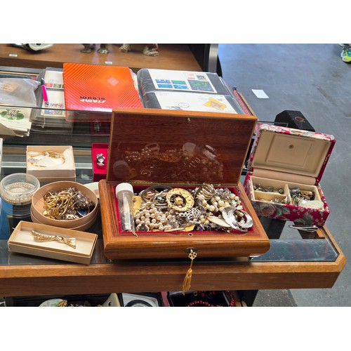 932 - A quantity of costume jewellery displayed over three shelves