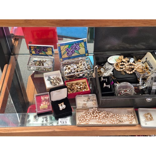 932 - A quantity of costume jewellery displayed over three shelves