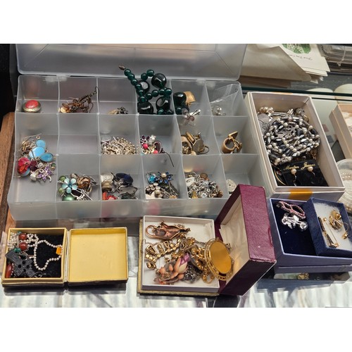 932 - A quantity of costume jewellery displayed over three shelves