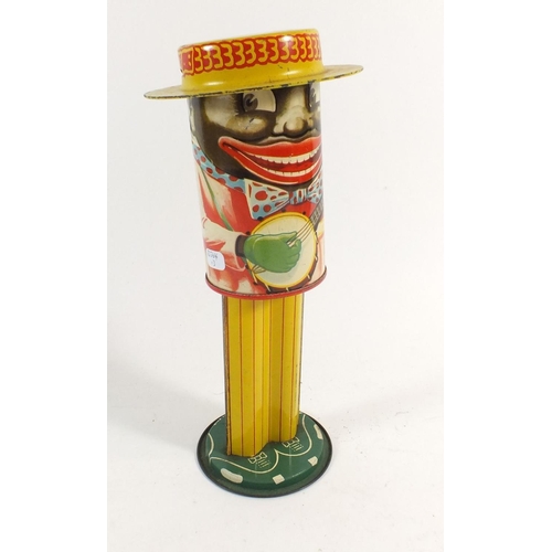 1088 - Americana. A 1920's tinplate movable money coin box in the form of a Black American banjo player - P... 