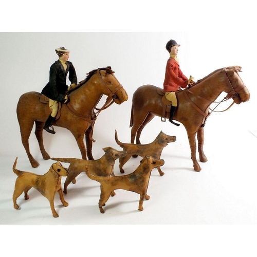 1089 - An early 20th century leather clad model toy hunting set comprising two horses, two riders and four ... 