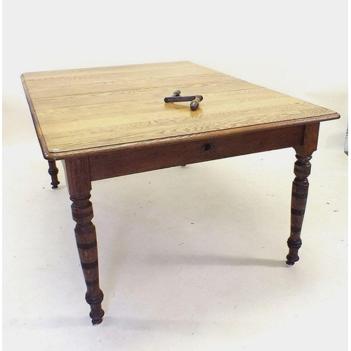 1173 - An Edwardian mid oak wind out dining table with two small interleaves all on turned supports