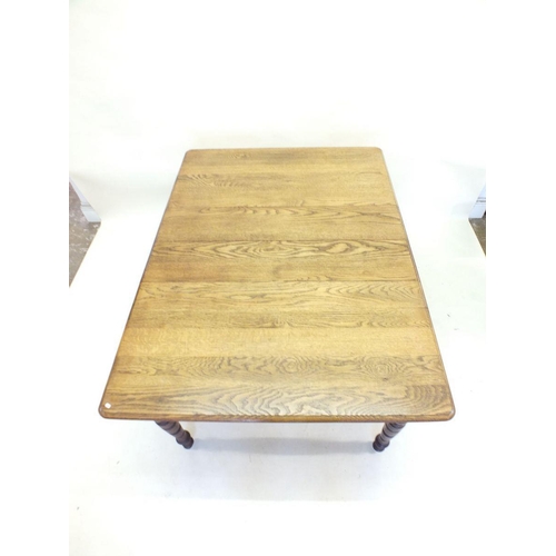 1173 - An Edwardian mid oak wind out dining table with two small interleaves all on turned supports