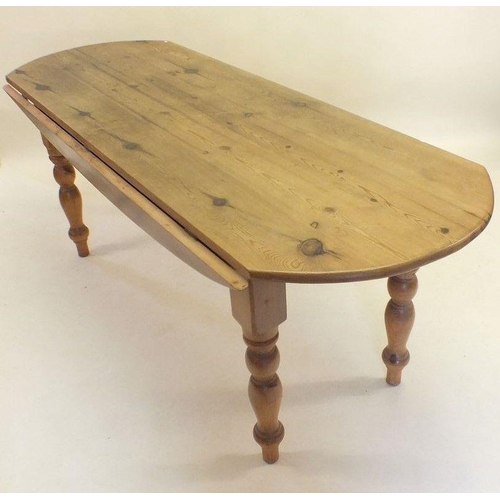 1174 - A long oval pine dropleaf kitchen table on turned supports