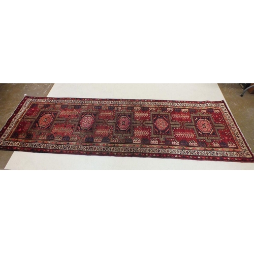 1180 - A full pile red ground Iranian runner with crossed door design, 306 x 95cm