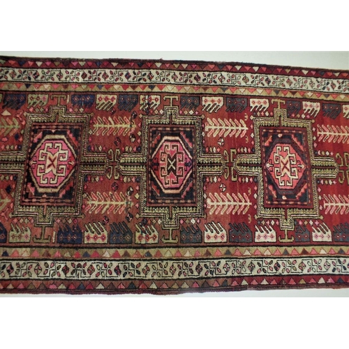 1180 - A full pile red ground Iranian runner with crossed door design, 306 x 95cm