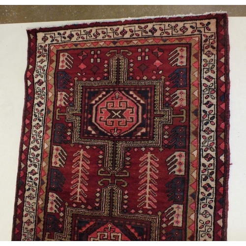 1180 - A full pile red ground Iranian runner with crossed door design, 306 x 95cm