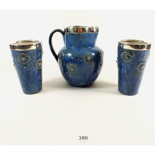 386 - A Royal Doulton blue stoneware jug and two beakers with silver rims, jug 18cm tall