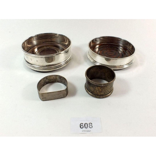 608 - A pair of silver bottle coasters and two silver napkin rings