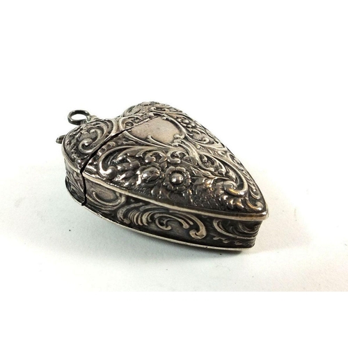 623A - A silver heart form pendant or chatelaine box with embossed decoration, import mark for London 1902,... 