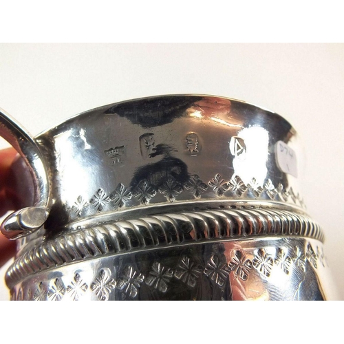 644 - A large Queen Anne silver porringer or caudle cup, London 1706 by John Abbott, with embossed decorat... 