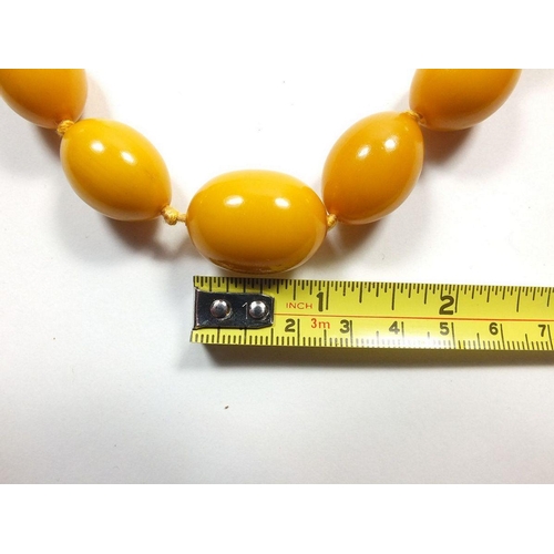 645 - A yellow amber bead necklace, 82gm, largest bead 2.5cm long