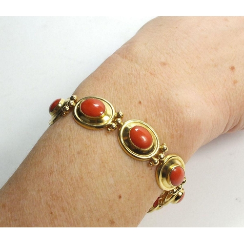 667 - An 18ct gold oval link bracelet set coral, 17g