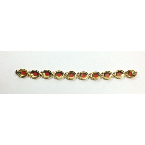 667 - An 18ct gold oval link bracelet set coral, 17g