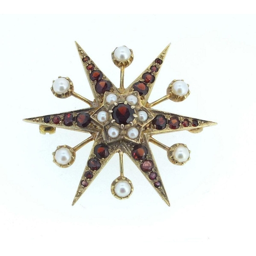 674 - A 9 carat gold garnet and pearl star form brooch, 7.5g, 3.8cm diameter