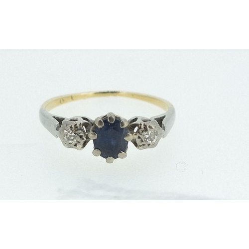 694 - A gold ring set sapphire, flanked by two diamonds - size H