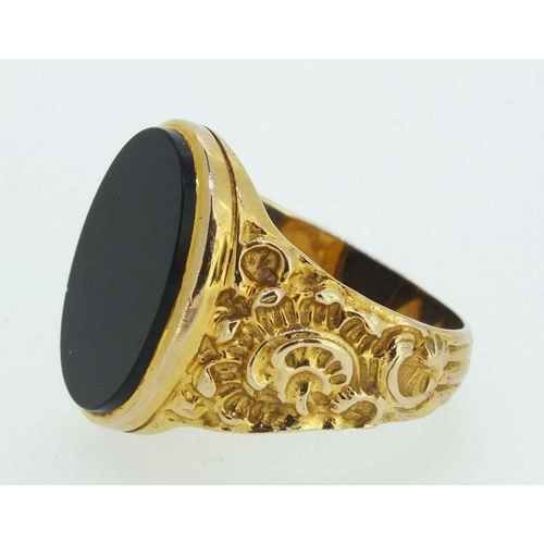 709 - A 9ct gold gentleman's ring with cast scrollwork decoration, inset black onyx, 9.5gm, size X-Y