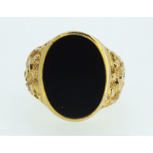 709 - A 9ct gold gentleman's ring with cast scrollwork decoration, inset black onyx, 9.5gm, size X-Y