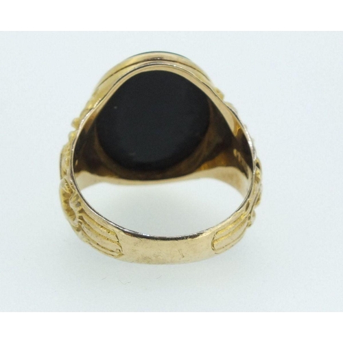 709 - A 9ct gold gentleman's ring with cast scrollwork decoration, inset black onyx, 9.5gm, size X-Y