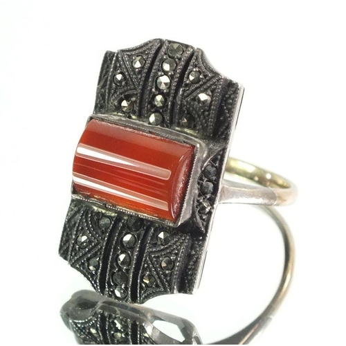 712 - An Art Deco marcasite and cornelian ring set in silver on 9 carat gold band, size M - N