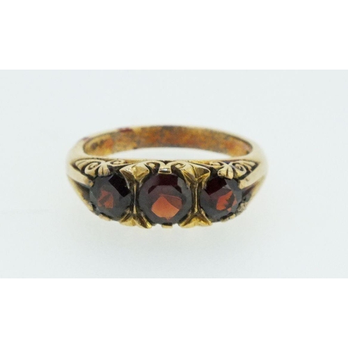 713 - A 9ct gold ring set three garnets - size O-P