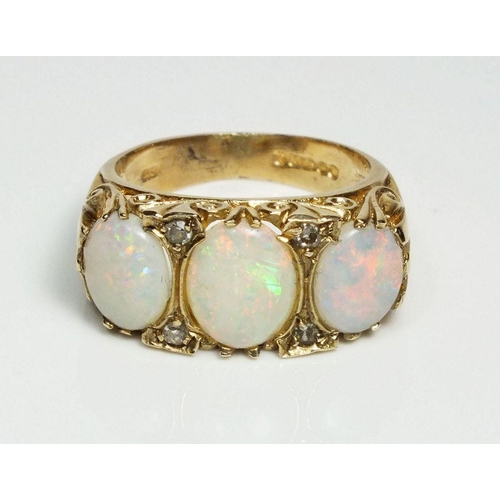 714 - A 9ct gold ring set three large opals flanked by  chip diamonds, size L-M, 4.2g