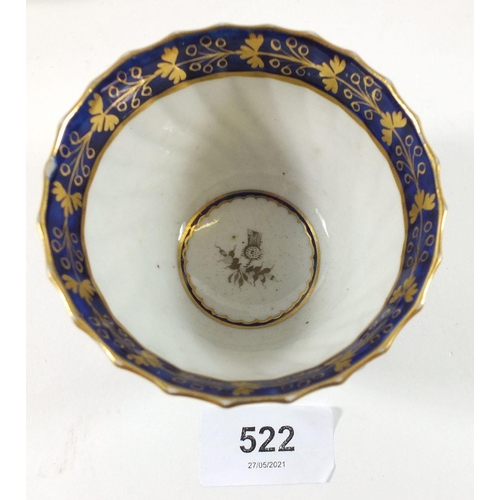 522 - An 18th century porcelain blue and white spiral fluted tea bowl with gold border and thistle decorat... 