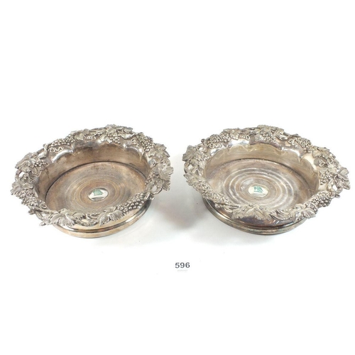 596 - A pair of silver plated and wooden bottle coasters with vine borders, 19cm diameter