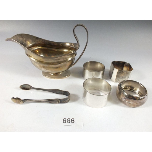 666 - A silver sauce boat, four napkin rings and a pair of sugar tongs, total weight 228g