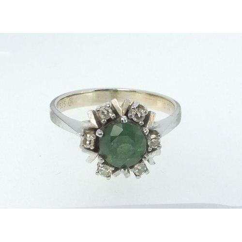 776 - A 14 carat white gold ring set emerald within diamond surround, size O