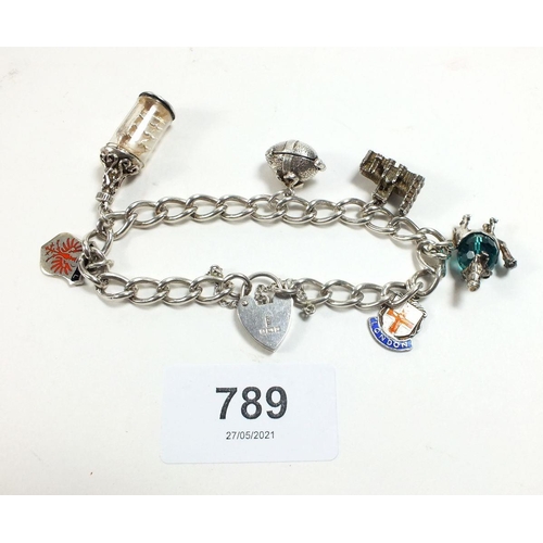 789 - A silver charm bracelet with six charms, 32g