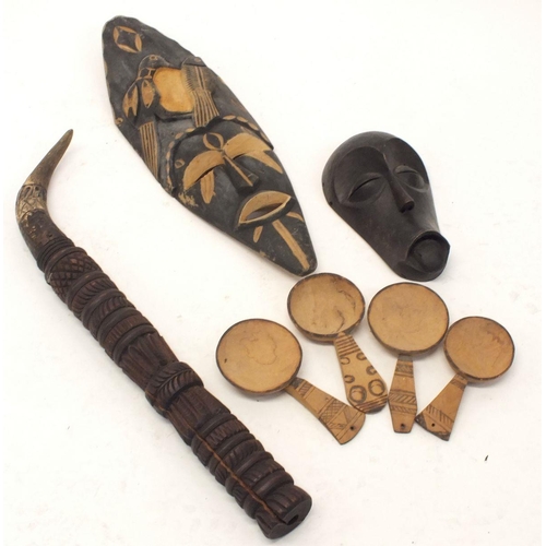 1025 - Two African wooden tribal masks, four Zambian tribal wooden spoons and a ceremonial musical wooden i... 