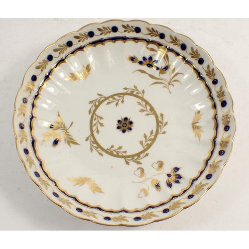 131 - An 18th century Worcester tea cup and saucer,  painted blue and gilt sprays with blue crescent mark