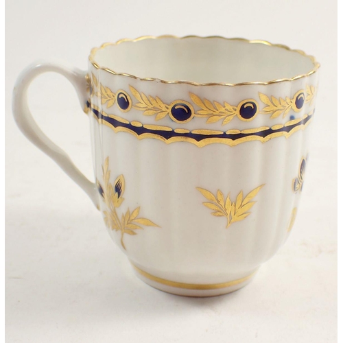 131 - An 18th century Worcester tea cup and saucer,  painted blue and gilt sprays with blue crescent mark