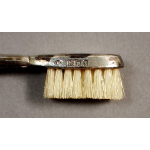 205 - An Edwardian silver travelling toothbrush, London 1910, approx 9cm long