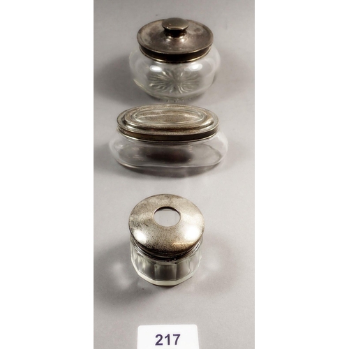 217 - Three silver-topped glass dressing table pots