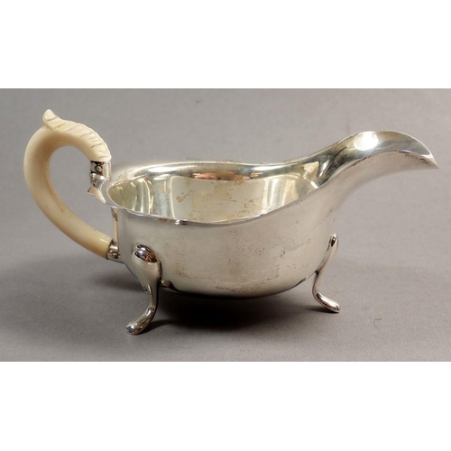 221 - A silver sauce boat with scalloped rim and carved ivory handle, Sheffield 1935, Maker Pearce & Sons,... 