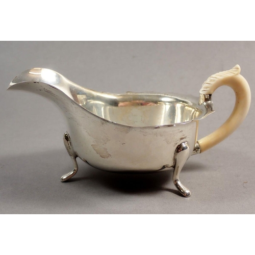 221 - A silver sauce boat with scalloped rim and carved ivory handle, Sheffield 1935, Maker Pearce & Sons,... 