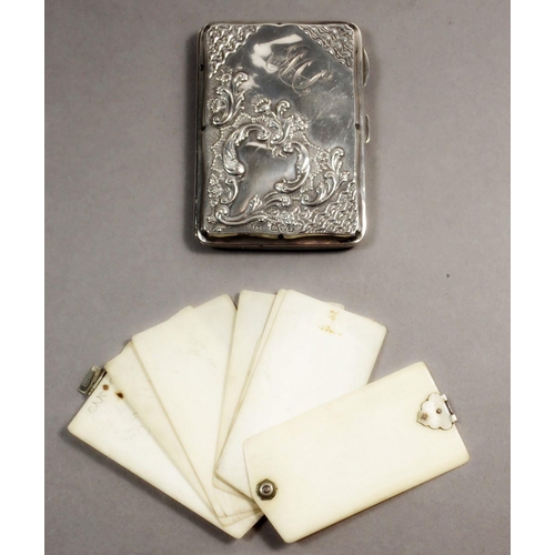 237 - An Edwardian silver note case with scroll decoration and fitted interior containing a pencil and ivo... 