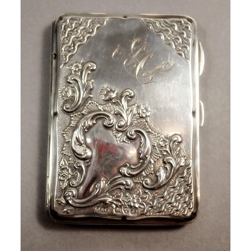 237 - An Edwardian silver note case with scroll decoration and fitted interior containing a pencil and ivo... 