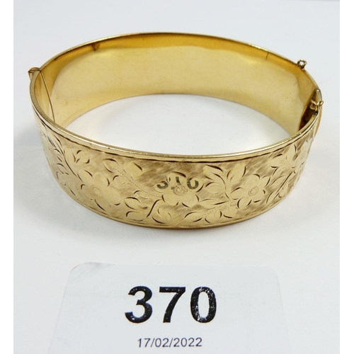 370 - A gold plated on metal core hinged bangle engraved flowers