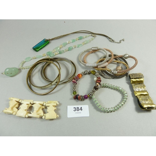 384 - An assortment of costume jewellery to include a bone bracelet, bangles, a beaded necklace etc