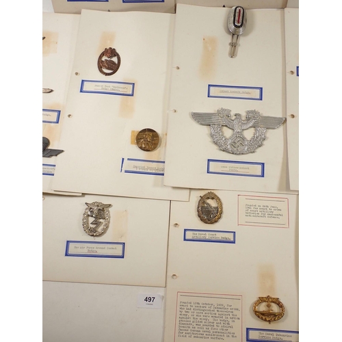 497 - A folder of German WWII Nazi cap badges and other badges, mounted on card and taped to reverse.  Inc... 