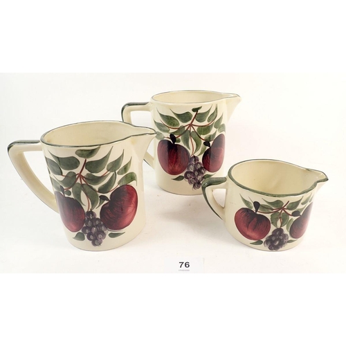 76 - Three Silstone graduated pottery jugs, painted fruits