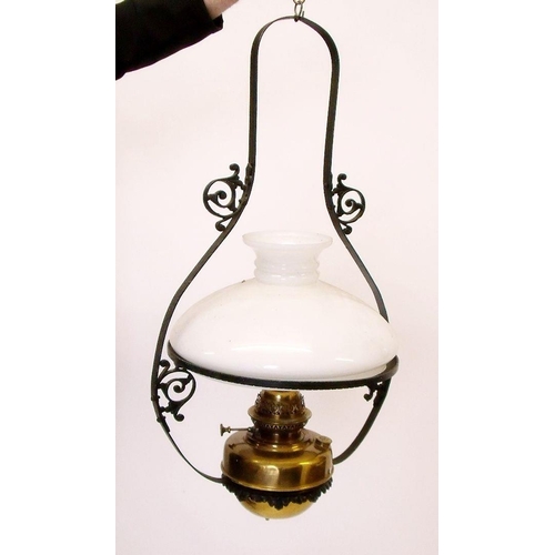 938 - A brass hanging oil lamp with glass shade and wrought iron hanger