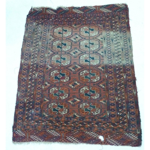 947 - An antique Turkoman style rug with two rows of six guls, 121 x 96cm - distressed