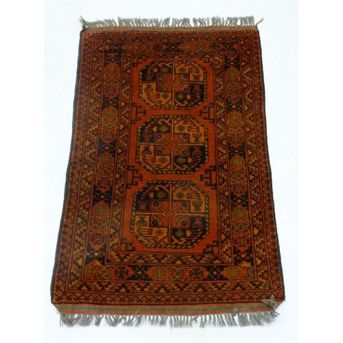 948 - A Middle Eastern rug with three guls on rust ground, 121 x 81cm