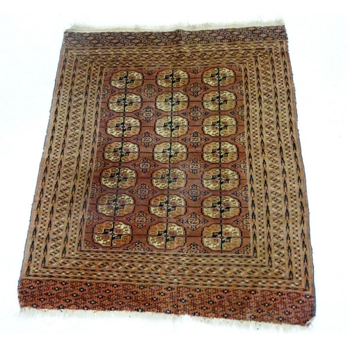 949 - A Turkoman rug with three rows of guls on a soft red ground 129cm x 109cm