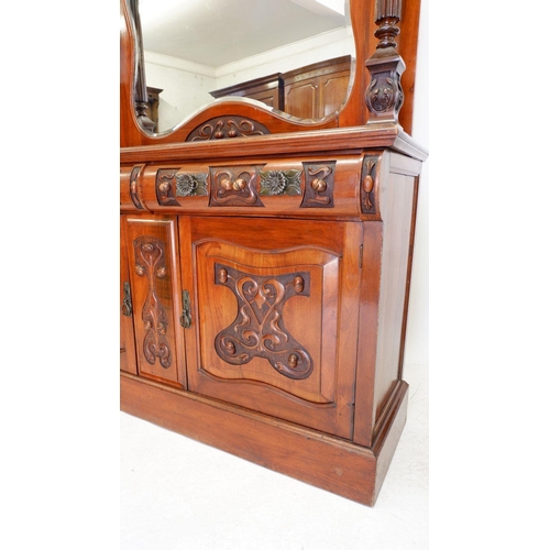 1279 - An Art Nouveau mirror back sideboard with ornately carved decoration of interwined stems and buds